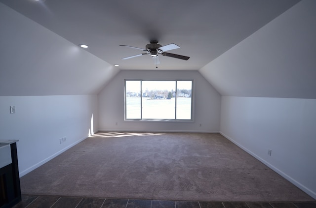 bonus room with dark carpet, lofted ceiling, baseboards, and ceiling fan