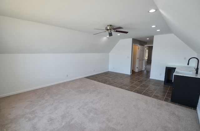 additional living space with baseboards, lofted ceiling, recessed lighting, dark colored carpet, and a sink