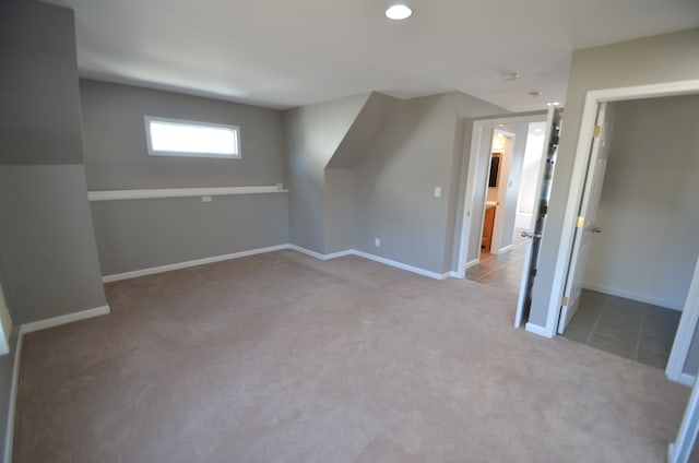 additional living space featuring carpet and baseboards