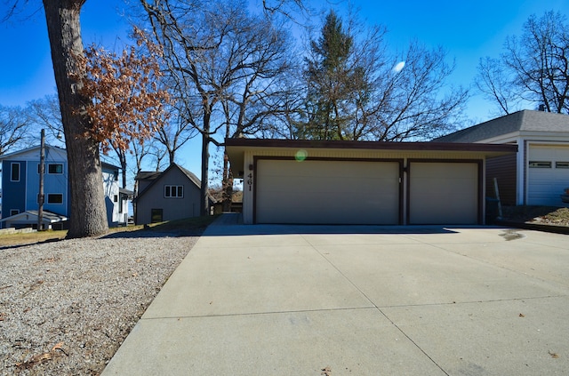 exterior space with an outbuilding, concrete driveway, and an attached garage