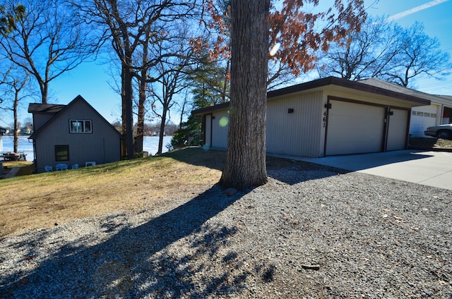 view of side of home with a yard, a garage, and driveway