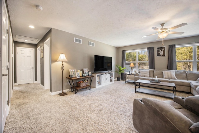 carpeted living area featuring baseboards, visible vents, and a textured ceiling