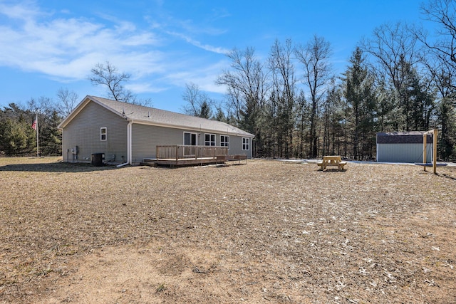 exterior space with cooling unit, an outbuilding, a deck, and a storage shed