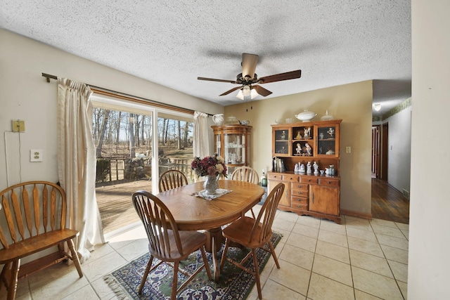 dining area featuring light tile patterned floors, a textured ceiling, and a ceiling fan