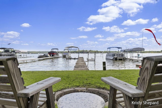 view of dock with a lawn and a water view