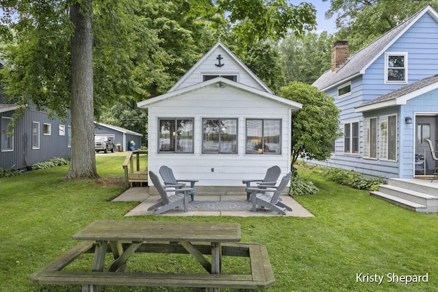 rear view of house featuring a patio and a lawn