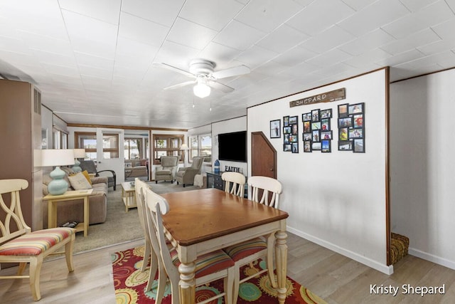 dining room featuring a ceiling fan, baseboards, and wood finished floors