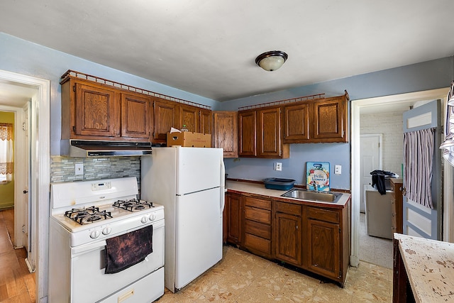 kitchen featuring a sink, tasteful backsplash, white appliances, light countertops, and extractor fan