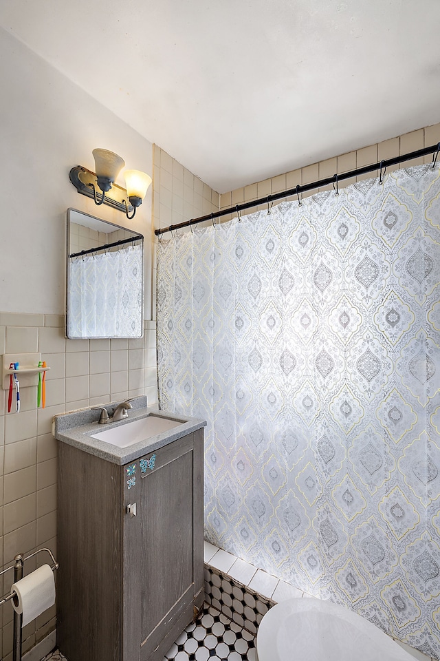 bathroom with vanity and tile walls