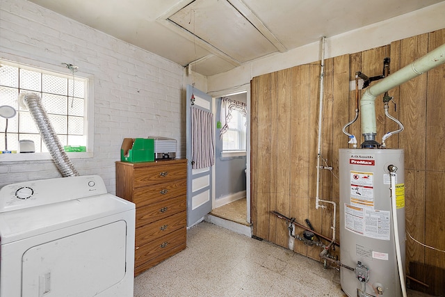 laundry room featuring light floors, attic access, water heater, laundry area, and washer / clothes dryer