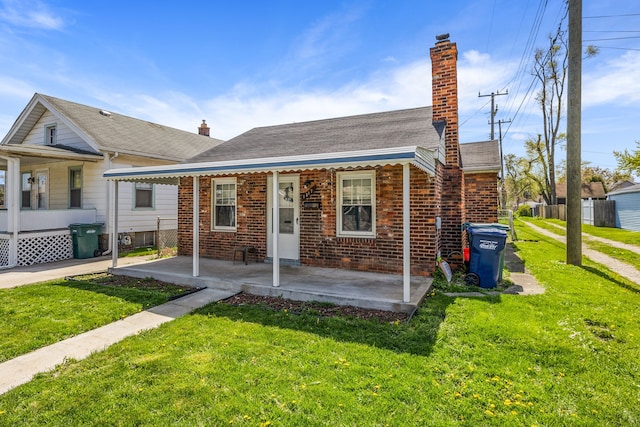 bungalow-style home featuring a front lawn, fence, brick siding, and a chimney