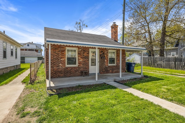 bungalow-style home with brick siding, a front yard, and fence