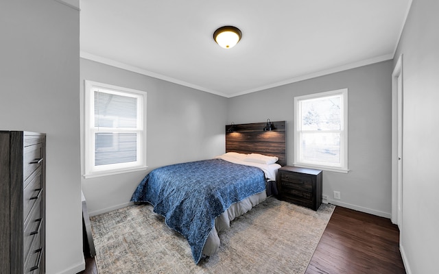 bedroom with crown molding, wood finished floors, and baseboards