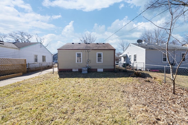 rear view of house with crawl space, a yard, and fence