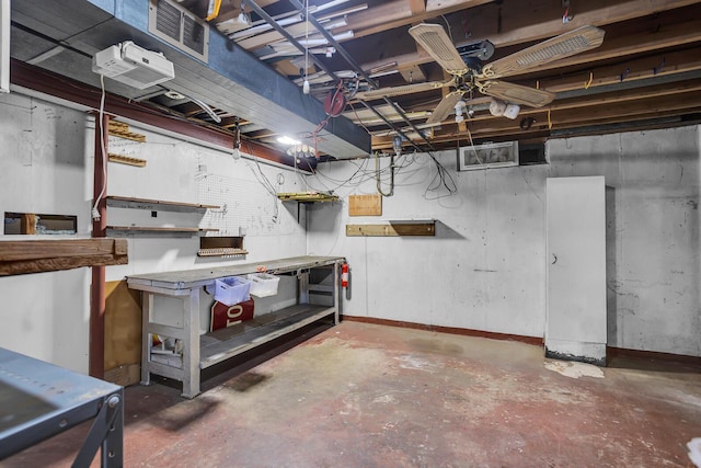 unfinished basement featuring visible vents, a workshop area, and baseboards