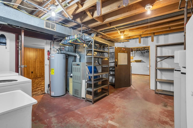 unfinished basement featuring gas water heater, visible vents, separate washer and dryer, and a sink