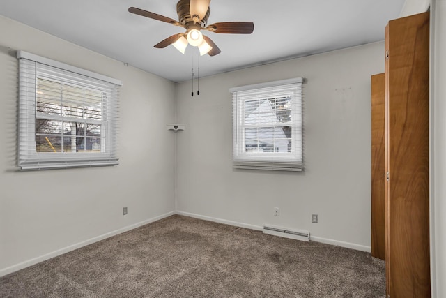 carpeted empty room featuring ceiling fan and baseboards