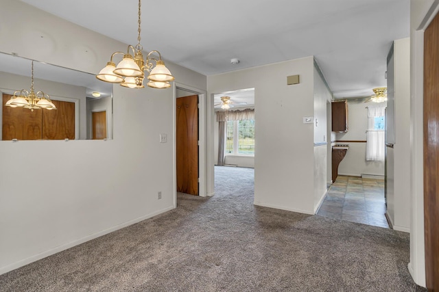 unfurnished dining area featuring ceiling fan with notable chandelier, carpet, and baseboards