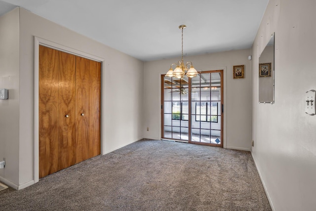 carpeted empty room with baseboards and a notable chandelier