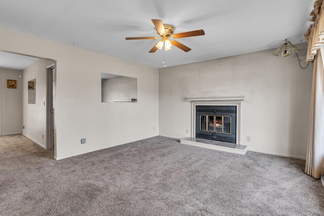 unfurnished living room with a glass covered fireplace, carpet flooring, and ceiling fan