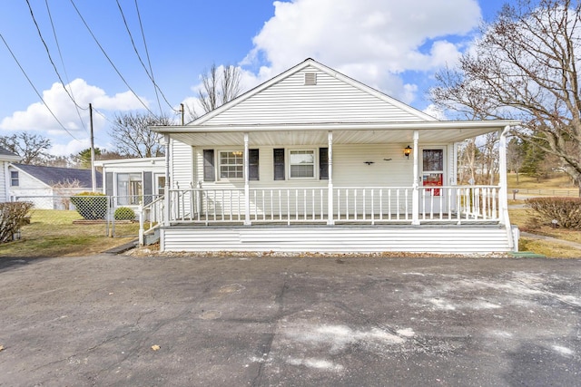 view of front of property featuring a porch and fence