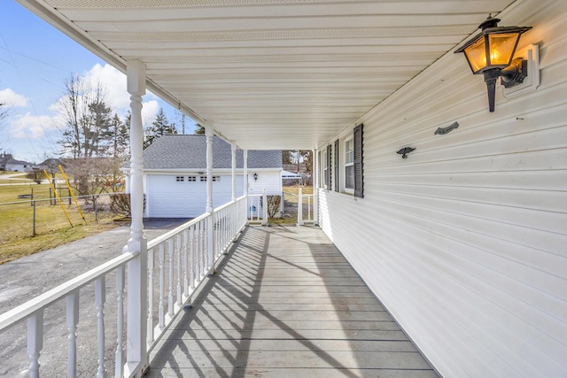 wooden deck featuring an outdoor structure, fence, and a garage