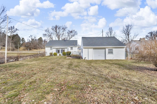 rear view of house with a yard, an outbuilding, and fence