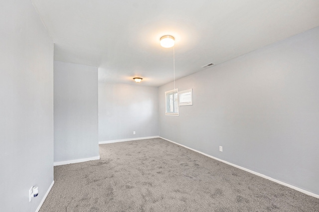 spare room with baseboards, visible vents, and carpet floors