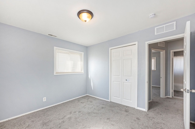 unfurnished bedroom featuring a closet, visible vents, and carpet floors