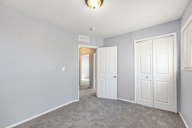 unfurnished bedroom with a closet, visible vents, baseboards, and carpet