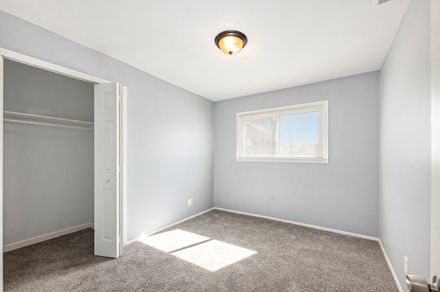 unfurnished bedroom with carpet flooring, baseboards, and a closet