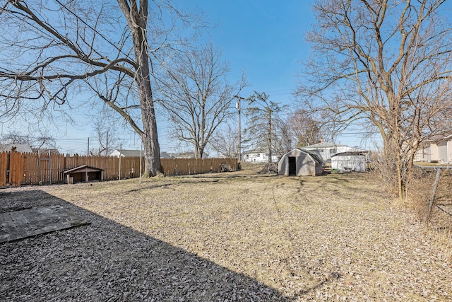 view of yard with an outbuilding, a shed, and fence