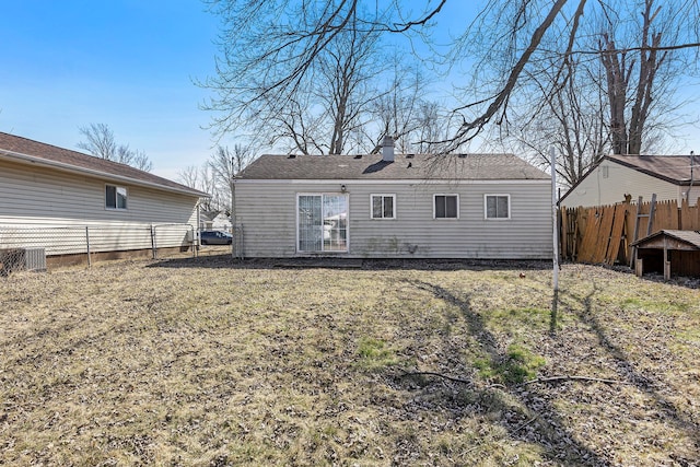 rear view of house with a fenced backyard