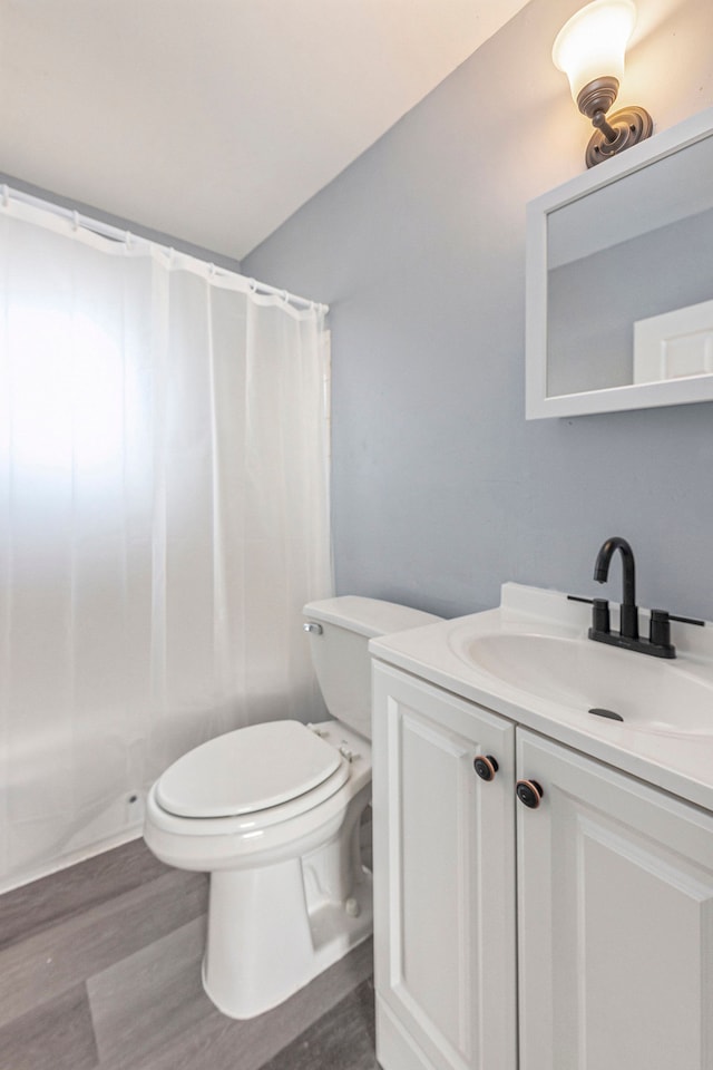 full bathroom with toilet, wood finished floors, and vanity