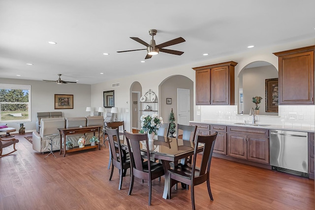 dining space featuring a ceiling fan, recessed lighting, wood finished floors, and arched walkways