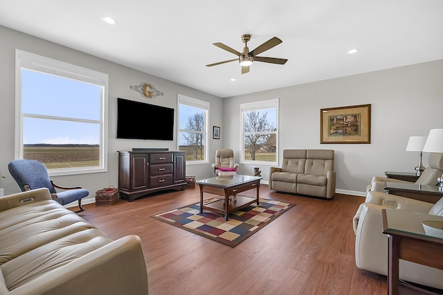 living area with a ceiling fan, recessed lighting, wood finished floors, and baseboards