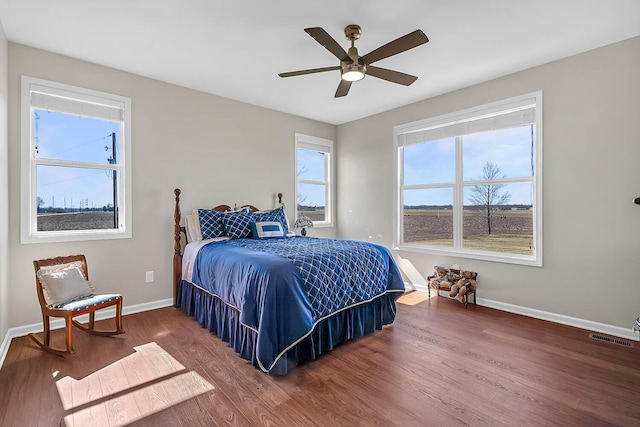 bedroom with visible vents, ceiling fan, baseboards, and wood finished floors