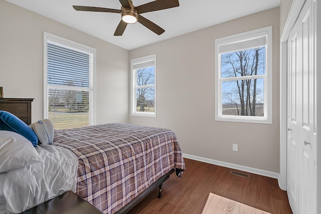 bedroom featuring visible vents, baseboards, a closet, and wood finished floors