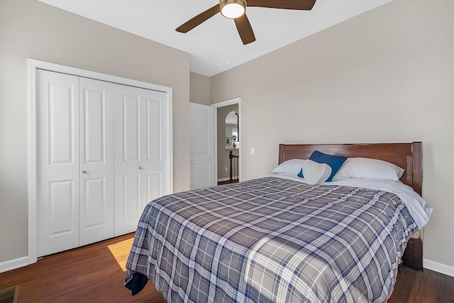 bedroom with a ceiling fan, wood finished floors, a closet, and baseboards