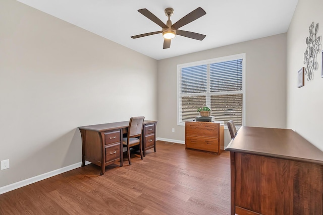 office space with baseboards, wood finished floors, and a ceiling fan