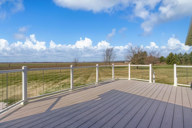 deck with a rural view and a lawn