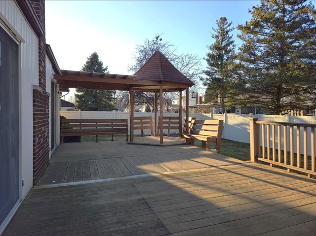 wooden terrace with a fenced backyard