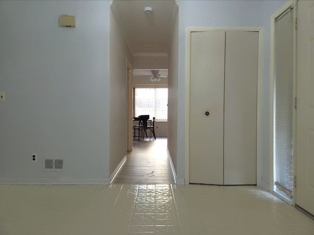 hallway featuring visible vents, baseboards, and ornamental molding