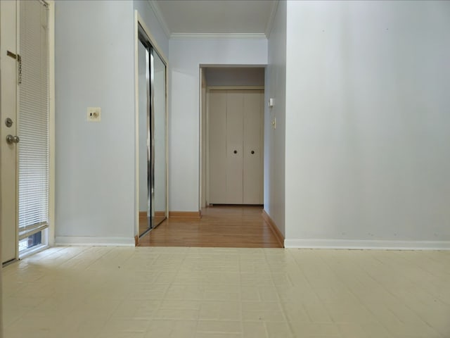 hall featuring baseboards and crown molding