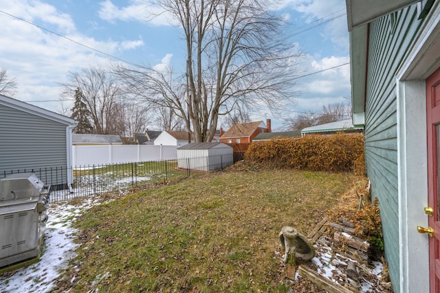 view of yard with an outbuilding, a storage unit, and a fenced backyard