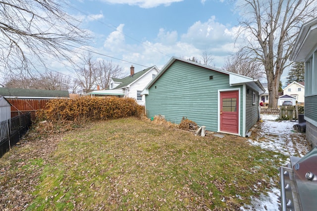 view of property exterior with a lawn and fence