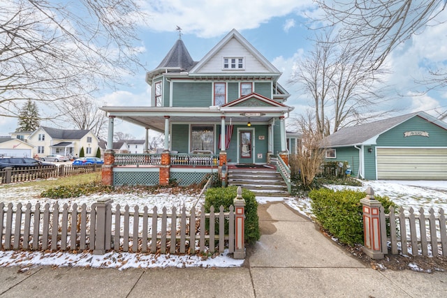 victorian house with a fenced front yard, covered porch, a detached garage, and an outdoor structure