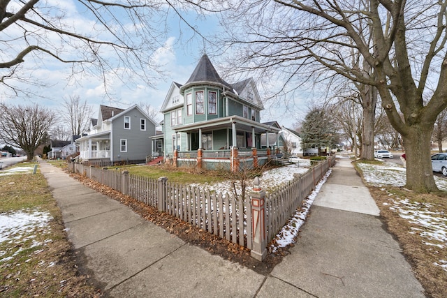 victorian-style house with a fenced front yard and a porch