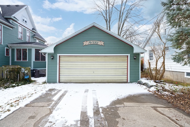 snow covered garage featuring a garage