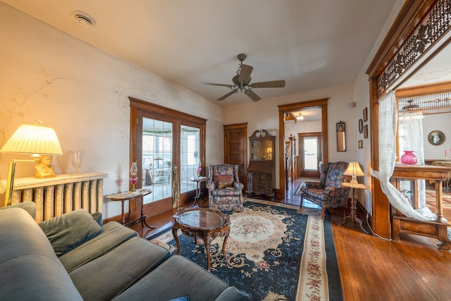 living room featuring hardwood / wood-style floors, french doors, baseboards, and a healthy amount of sunlight